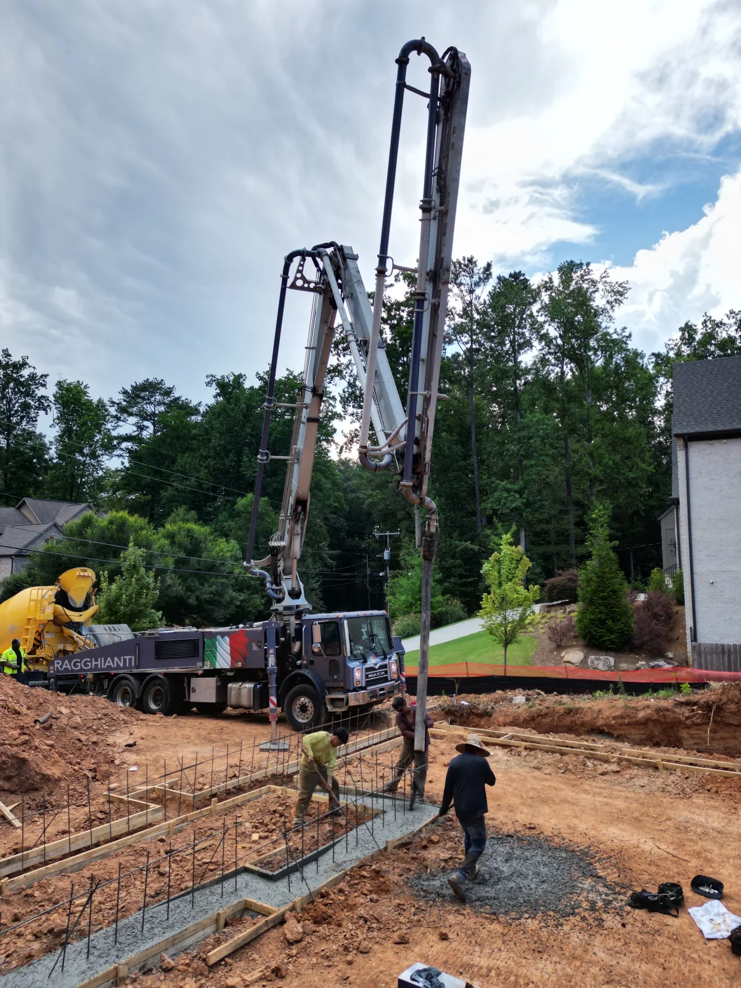 Crew placing concrete into reinforced footings